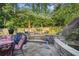Cozy backyard with stone patio, outdoor seating, koi pond, and mature landscaping at 4731 Moon Chase Dr, Buford, GA 30519