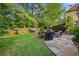Landscaped backyard with stone patio, koi pond, well maintained lawn, and privacy fence at 4731 Moon Chase Dr, Buford, GA 30519