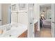 Clean bathroom with white countertops, wood cabinets, and an open doorway to the bedroom at 4731 Moon Chase Dr, Buford, GA 30519