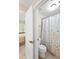 Bathroom with toilet, shower/tub combo with decorative curtain and a view into the bedroom at 4731 Moon Chase Dr, Buford, GA 30519