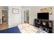 Cozy bedroom featuring a media console, neutral walls, and view into hallway and adjacent rooms at 4731 Moon Chase Dr, Buford, GA 30519