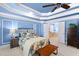 This bedroom features a tray ceiling, crown molding, and access to an ensuite bathroom at 4731 Moon Chase Dr, Buford, GA 30519