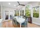 Bright dining area features large windows and access to the outdoor deck with hardwood floors and modern light fixture at 4731 Moon Chase Dr, Buford, GA 30519