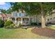 Beautiful brick home with a covered front porch and mature tree, offering shade and curb appeal at 4731 Moon Chase Dr, Buford, GA 30519