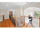 Second floor hallway with hardwood flooring, telescope, and decorative wrought iron spindles at 4731 Moon Chase Dr, Buford, GA 30519