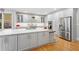 Spacious kitchen with stainless steel appliances, large center island and ample cabinet storage with hardwood floor at 4731 Moon Chase Dr, Buford, GA 30519