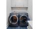 Laundry room with full size washer and dryer, storage cabinets, tile floor and bright modern lighting at 4731 Moon Chase Dr, Buford, GA 30519