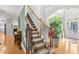 Elegant home staircase featuring carpeted steps with decorative trim and a large plant in a pot near the entrance at 4731 Moon Chase Dr, Buford, GA 30519