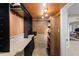 This wine cellar features black wine racks and a wooden bookshelf with a small view into another room at 4731 Moon Chase Dr, Buford, GA 30519