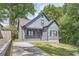 Charming home featuring a quaint front porch and traditional architectural details surrounded by mature trees and manicured lawn at 558 Elbridge Nw Dr, Atlanta, GA 30318