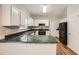 Efficient kitchen featuring white cabinetry, sleek countertops, and modern appliances, complemented by hardwood floors at 558 Elbridge Nw Dr, Atlanta, GA 30318