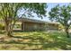 Brick house with large lawn, patio, and covered carport viewed from the yard at 6459 Paula Ct, Rex, GA 30273