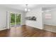 Open dining room with hardwood floors, slider doors to the backyard, and a view of the kitchen at 6459 Paula Ct, Rex, GA 30273