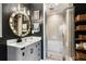 Modern bathroom features a white vanity, round mirror, and glass-enclosed shower over tub at 791 Wylie Se St # 911, Atlanta, GA 30316