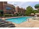 Beautiful community pool with lounge chairs, manicured landscaping, and attractive brick buildings at 791 Wylie Se St # 911, Atlanta, GA 30316