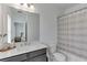 Bathroom with a marble countertop, vanity, large mirror, toilet, and shower with white and gray curtain at 1117 Larkin Dr, Buford, GA 30518