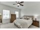 Well-lit bedroom with a ceiling fan, dresser, carpet, neutral decor and two windows at 1117 Larkin Dr, Buford, GA 30518