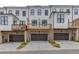 Modern townhomes featuring brick accents, attached garages, and rear decks overlooking neighborhood at 1117 Larkin Dr, Buford, GA 30518