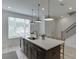 Kitchen island featuring modern pendant lights, stainless steel dishwasher, and a sleek faucet at 1117 Larkin Dr, Buford, GA 30518