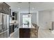 Bright kitchen with stainless appliances, dark cabinets, large island, and pendant lighting at 1117 Larkin Dr, Buford, GA 30518