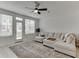Airy living room with large windows, modern ceiling fan, and comfortable sectional sofa at 1117 Larkin Dr, Buford, GA 30518