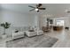 Open-concept living room with sectional sofa, ceiling fan and seamless flow into the modern kitchen at 1117 Larkin Dr, Buford, GA 30518