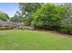 Lush backyard featuring green grass, landscaping, seating area, and a wooden fence at 2023 Yellow Finch Trl, Atlanta, GA 30316