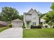 Charming two-story home featuring a green door, a well-manicured lawn, and a detached garage at 2023 Yellow Finch Trl, Atlanta, GA 30316