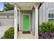 Close-up of a charming home's entry featuring a vibrant green door and manicured landscaping at 2023 Yellow Finch Trl, Atlanta, GA 30316