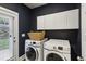 Well-organized laundry area with modern washer and dryer set, plus white cabinets for storage at 2023 Yellow Finch Trl, Atlanta, GA 30316