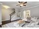 Inviting living room featuring a ceiling fan, stylish decor, wood floors, and staircase to the upper level at 2023 Yellow Finch Trl, Atlanta, GA 30316