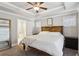 Spacious main bedroom with a tray ceiling, a ceiling fan, and a decorative wooden headboard at 2023 Yellow Finch Trl, Atlanta, GA 30316
