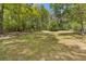 Expansive grassy backyard surrounded by mature trees, creating a serene and private outdoor space at 2377 Pine Mountain Rd, Kennesaw, GA 30152