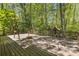 Backyard wooden deck featuring a swing set and a playhouse, surrounded by towering trees at 2377 Pine Mountain Rd, Kennesaw, GA 30152
