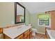 Bathroom with wood cabinets, a sink, toilet, window, mirror, and bathtub at 2377 Pine Mountain Rd, Kennesaw, GA 30152