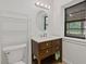 Bathroom features a dark wood vanity, updated fixtures, an oval mirror, and a window to the exterior at 2377 Pine Mountain Rd, Kennesaw, GA 30152