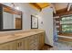 Bathroom featuring double sinks, wooden cabinets, and shower with natural light at 2377 Pine Mountain Rd, Kennesaw, GA 30152