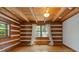 Bright bedroom featuring wood plank walls, hardwood floors, and plenty of natural light from a large window at 2377 Pine Mountain Rd, Kennesaw, GA 30152