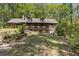 Charming log home with a welcoming front porch, nestled among lush trees and beautiful landscaping at 2377 Pine Mountain Rd, Kennesaw, GA 30152