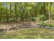 Stone steps lead to a charming garden gate, framed by lush greenery and blooming foliage at 2377 Pine Mountain Rd, Kennesaw, GA 30152