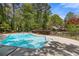 Sparkling pool with an expansive deck, set against a backdrop of verdant trees and blue sky at 2377 Pine Mountain Rd, Kennesaw, GA 30152