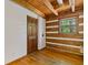 Cozy room with wooden walls, wooden floors, a window showcasing nature, and a wooden door at 2377 Pine Mountain Rd, Kennesaw, GA 30152