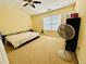 Bright bedroom with neutral carpet, a ceiling fan, and a large window at 6156 Thorncrest Dr, Tucker, GA 30084