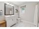 Bright bathroom featuring a white vanity, a decorative mirror, and white tile flooring at 831 Terrace Trce, Lawrenceville, GA 30044