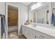 Well-lit bathroom with white cabinets, marble countertops, large mirror, and a tiled shower with a glass door at 831 Terrace Trce, Lawrenceville, GA 30044