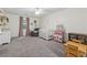Carpeted bedroom featuring a ceiling fan, a crib and a wooden play table at 831 Terrace Trce, Lawrenceville, GA 30044