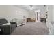 Spacious carpeted bedroom featuring a crib, ceiling fan and a gray armchair at 831 Terrace Trce, Lawrenceville, GA 30044
