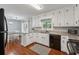 Kitchen featuring white cabinets, granite countertops, subway tile backsplash and wood flooring at 831 Terrace Trce, Lawrenceville, GA 30044