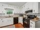 Kitchen featuring white cabinets, granite countertops, subway tile backsplash and wood flooring at 831 Terrace Trce, Lawrenceville, GA 30044
