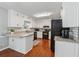 Kitchen featuring white cabinets, granite countertops, subway tile backsplash and wood flooring at 831 Terrace Trce, Lawrenceville, GA 30044